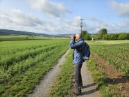 Mann mit Fernglas am Acker 