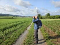 Mann mit Fernglas am Acker